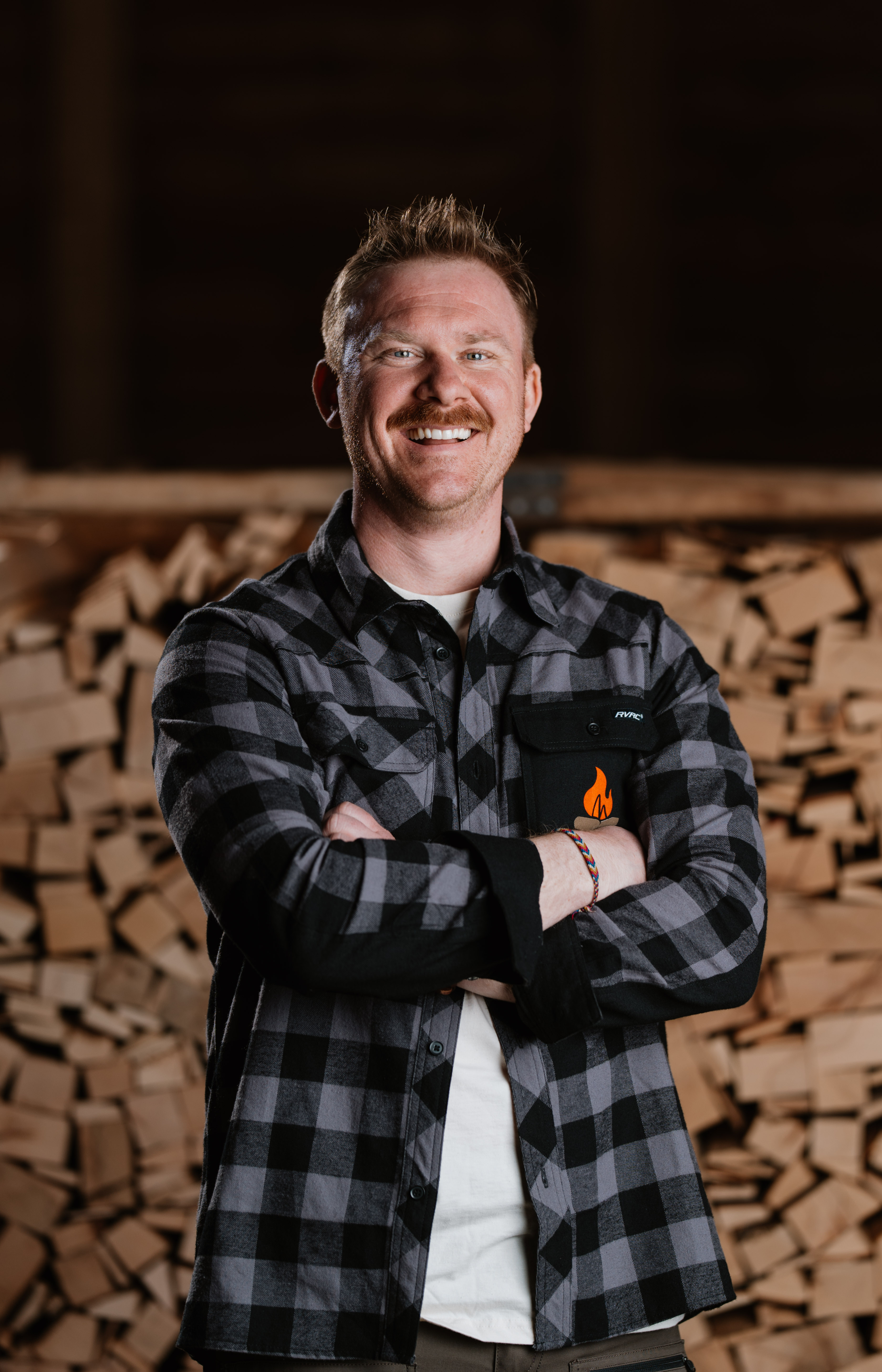 Portrait von Reinhard Mitterbauer mit Holzbriketts und Holzpellets in Freyung-Grafenau