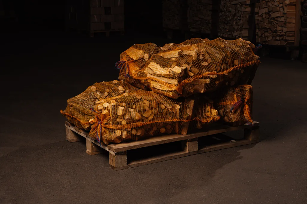 Kleines Brennholz in Netzsäcken separat auf Palette